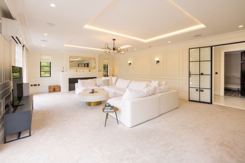 A living room beneath a lit coffered ceiling