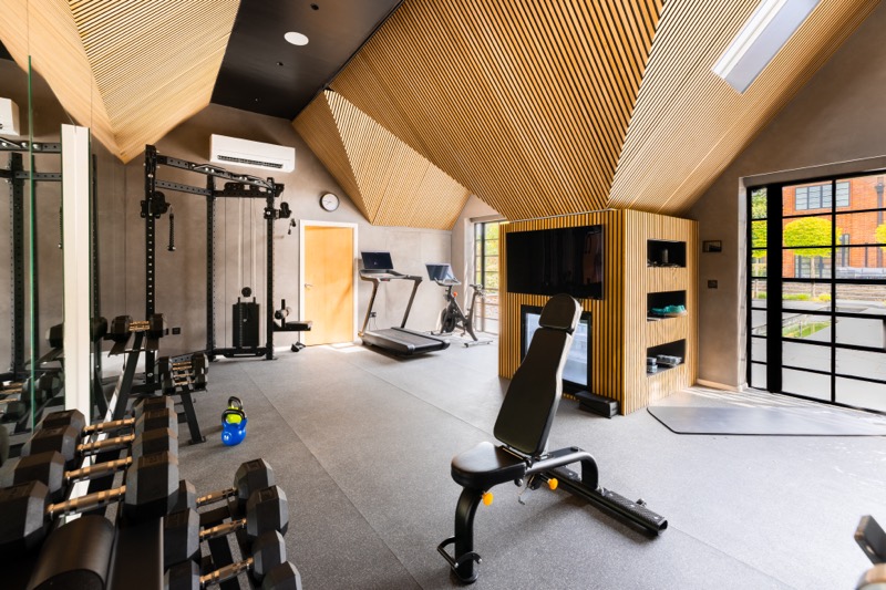 A home gym under a timber slatted ceiling