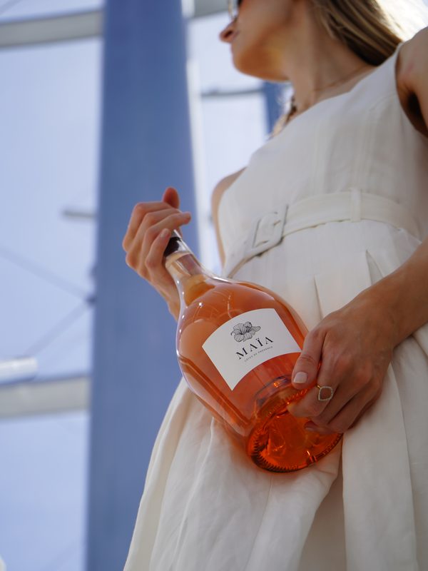 A guest on board holding a bottle of Maïa rosé